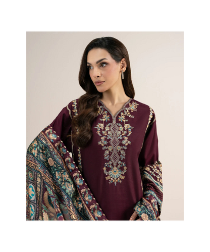A woman modeling a deep maroon traditional embroidered kurta with a matching patterned dupatta against a plain beige background.
